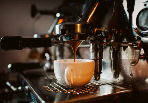 espresso machine pouring coffee into cups